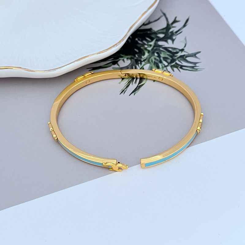 Gold-tone enamel T motif bangle with sky blue inner stripe and link charm