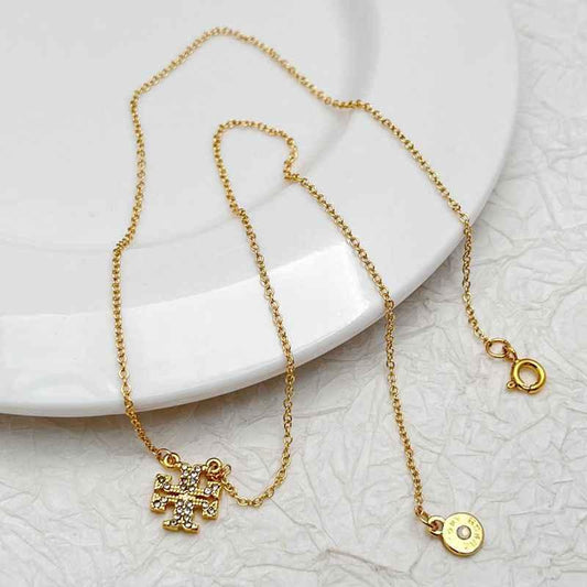 Gold rhinestone cross pendant necklace with round charm and C clasp
