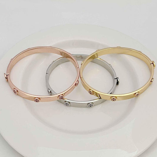 Gold and silver open bangle bracelets with embossed logo accents