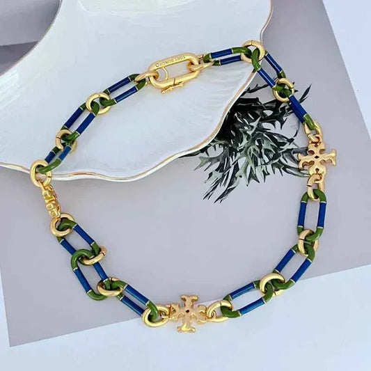 Enamel chain necklace with blue and green links, gold clasp, and dangling cross charm