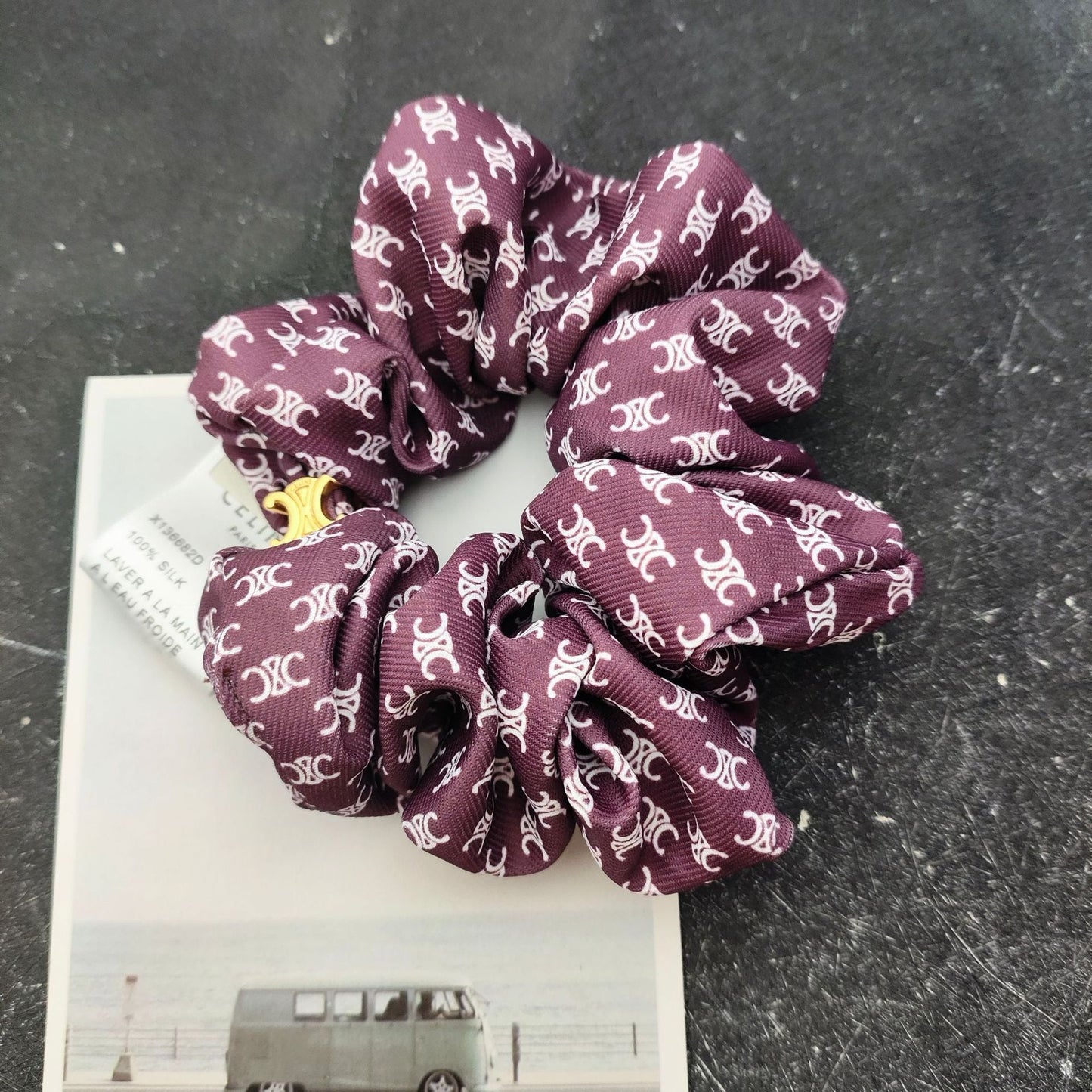 Hair tie in deep burgundy with white ornate print and gold clasp