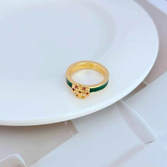 Enamel ring with gold-tone bezel, small raised emblem, and green enamel band