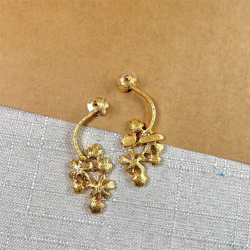 Gold hoop stud earrings with three-dimensional floral charm clusters