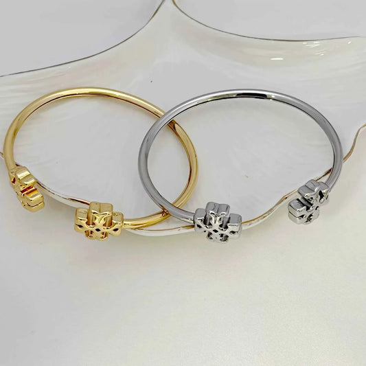 Set of open Tory Burch double logo metal bangles, gold and silver tones