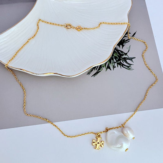 Gold metal necklace with baroque pearl pendants and small logo charm, adjustable chain