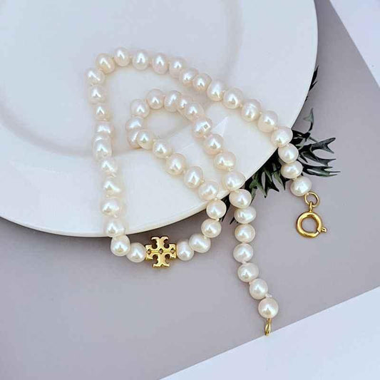 Freshwater pearl necklace with gold logo charm and dangling O-ring accent