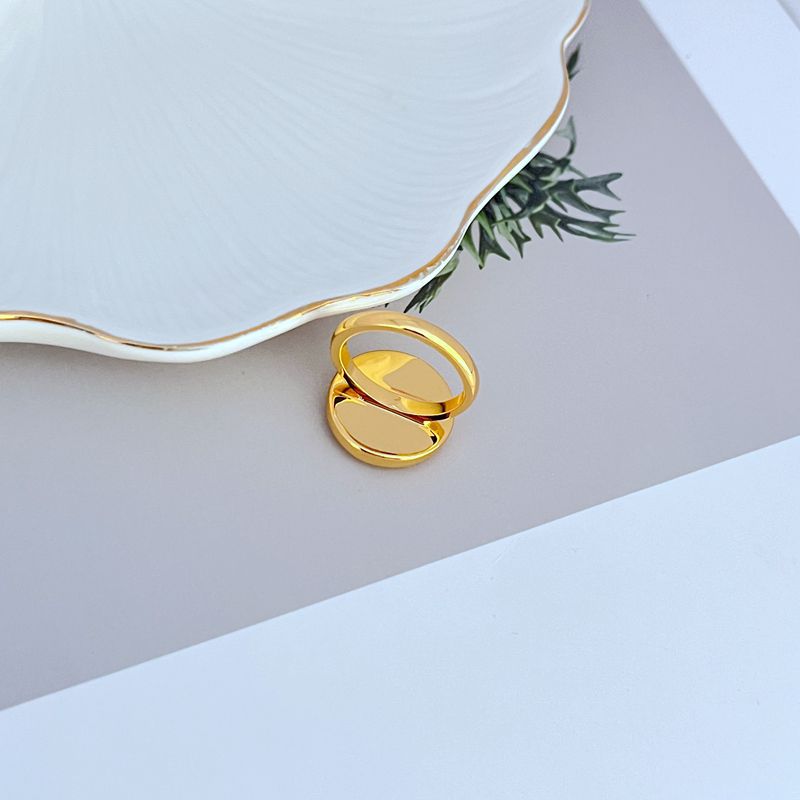 Gold-tone enamel logo ring, profile view of round bezel and band