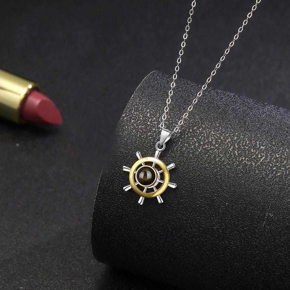 Gold ship wheel projection necklace on chain, round wheel pendant with dark center