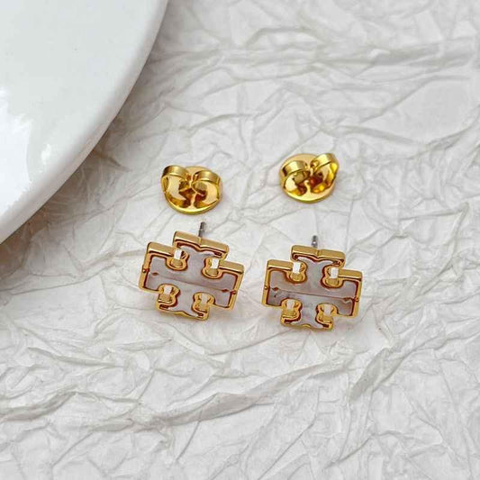Gold-tone stud earrings with Tory logo face and round post backs, light enamel