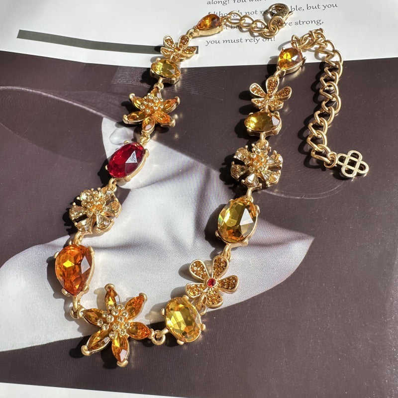 Gold-tone floral rhinestone necklace with orange, red, and yellow faceted gemstone accents