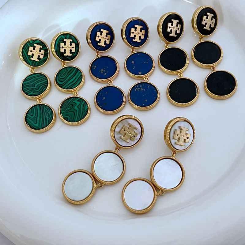 Assorted round shell dangle earrings with gold-tone logo medallions and linked drops