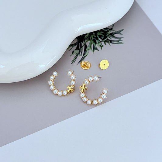 Gold pearl hoop earrings with white beads and small logo charm, pair view