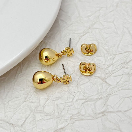 Gold-tone teardrop pendant earrings laid flat, showing stud posts and backing
