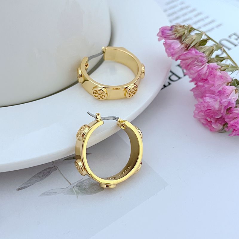 Gold logo hoop earrings angled view with textured emblem accents on hoops