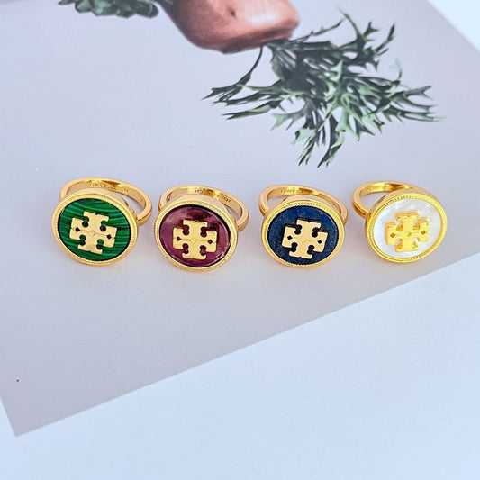 Set of 4 round enamel logo rings: green, purple, dark blue, and white centers