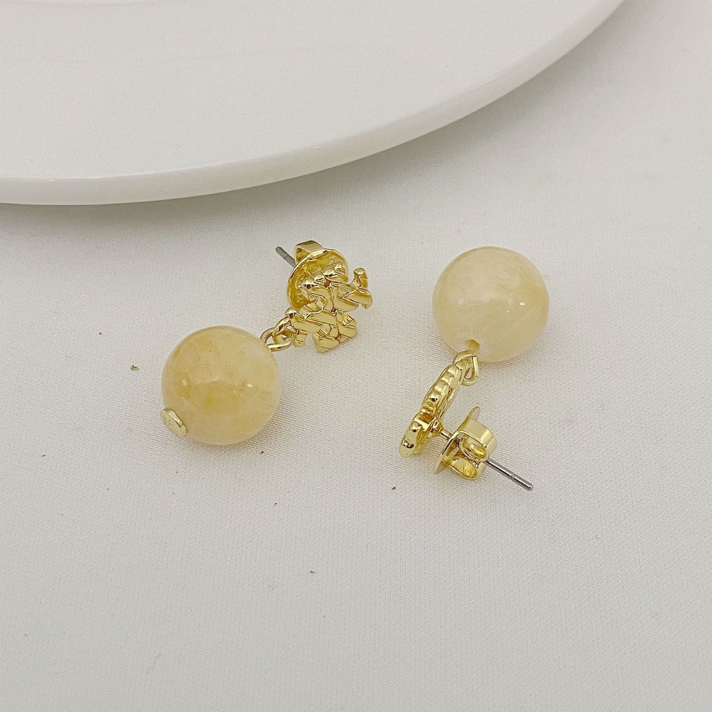 Round off-white agate bead earrings with gold logo charm and stud back