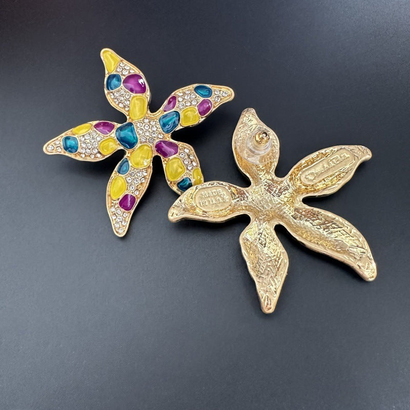 Starfish flower earrings showing gold-tone back with engraving; front with purple/yellow/blue