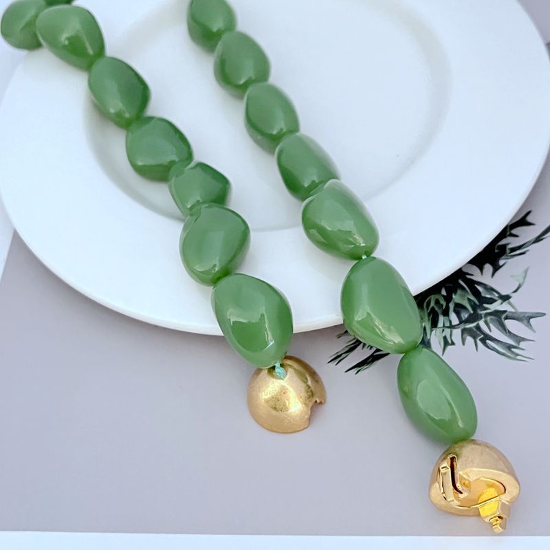 Green acrylic bead necklace with gold end caps and gold logo pendant