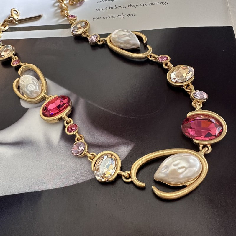 Gold-tone O-ring glass pearl necklace with fuchsia teardrop and cream pearl charms