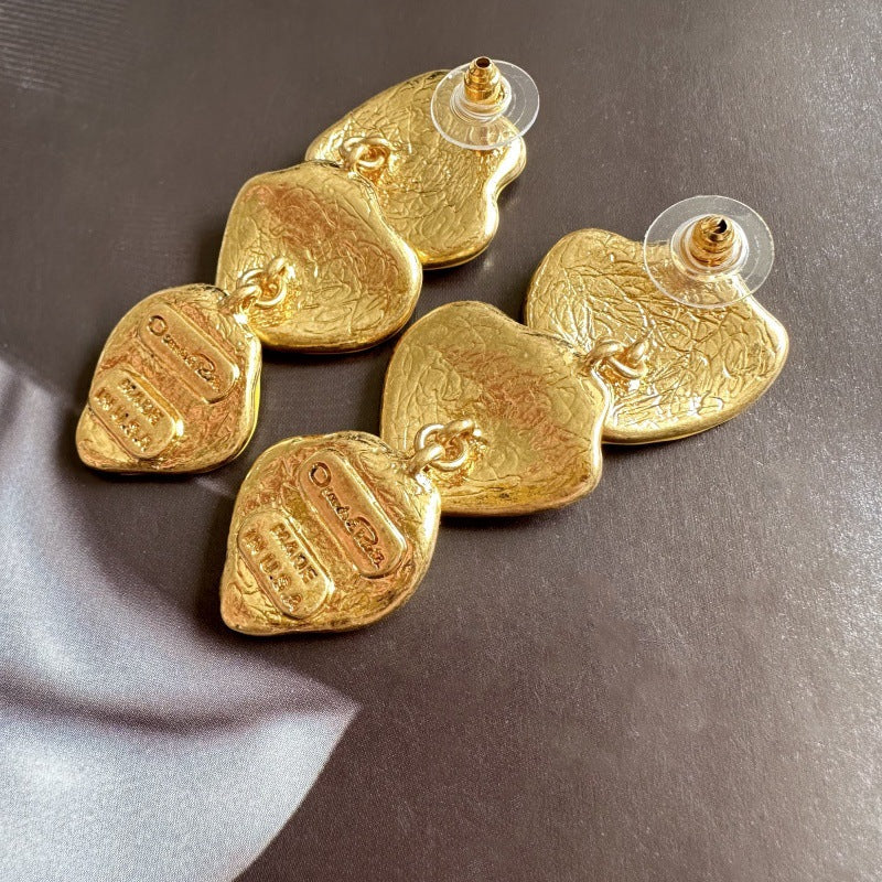 Gold-plated leaf pendant earrings with gold-tone enamel heart shapes and stud posts