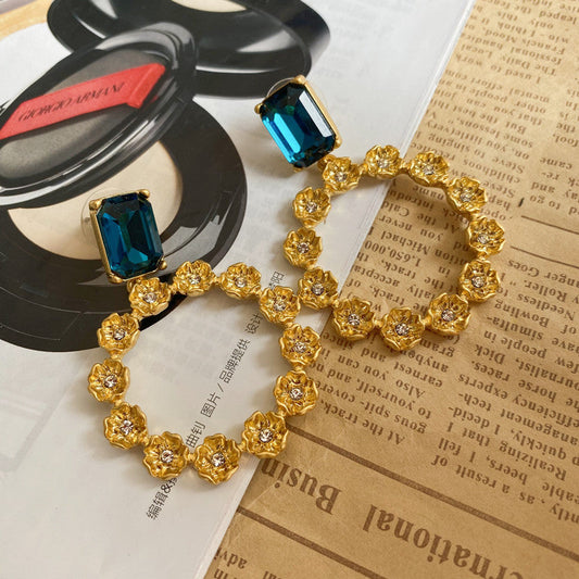 Large round floral hoop earrings with blue square stones and gold zircon clusters