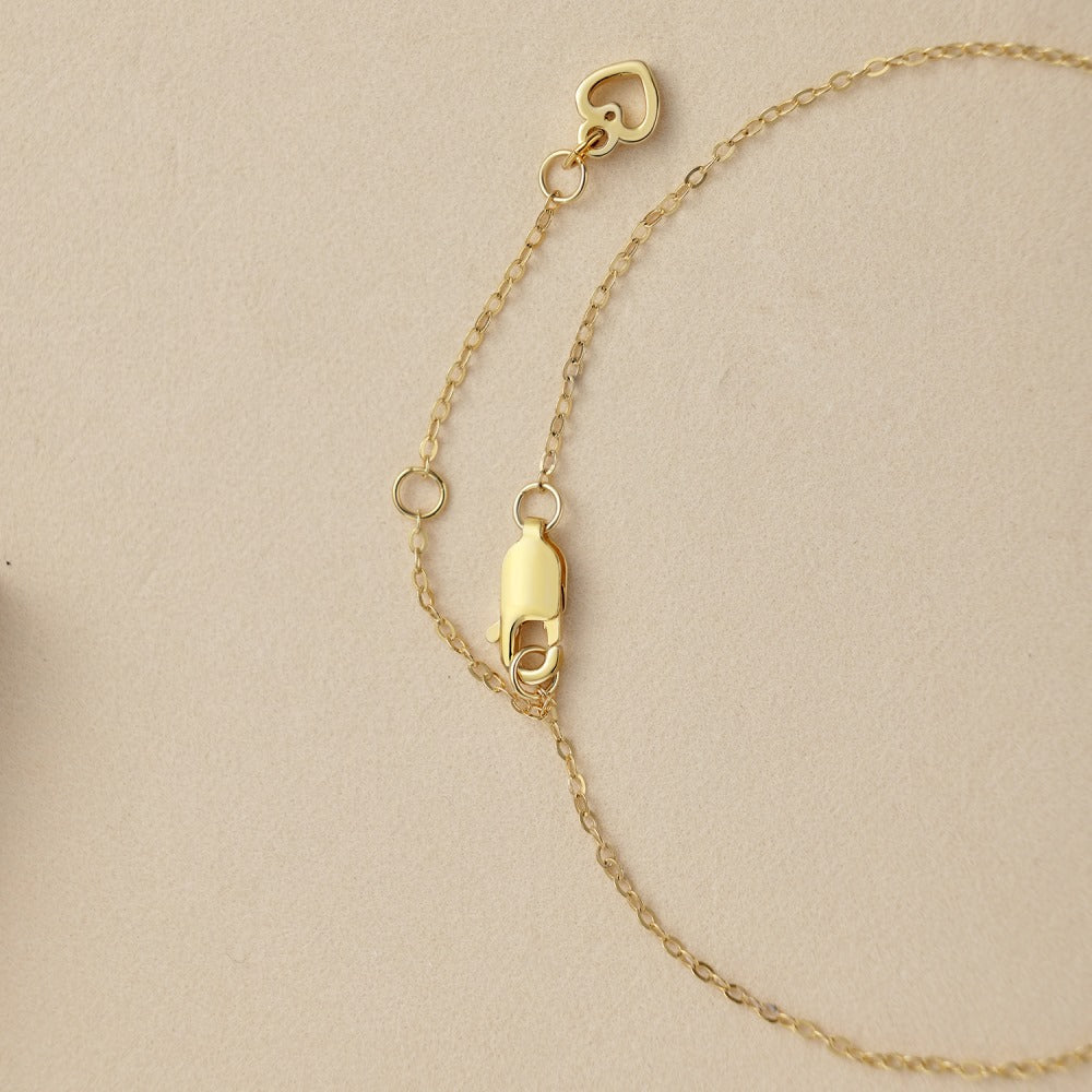 Gold chain bracelet with heart-shaped charm and secure clasp