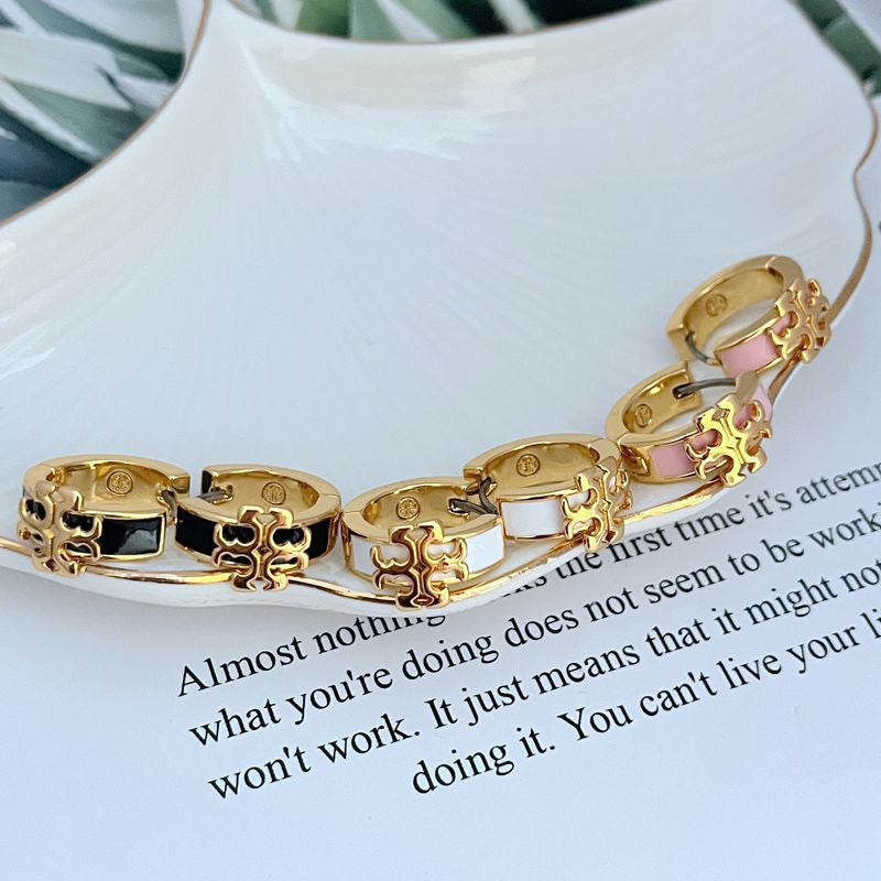 Enamel logo metal earrings with pink enamel and gold-tone detailing, hoop style