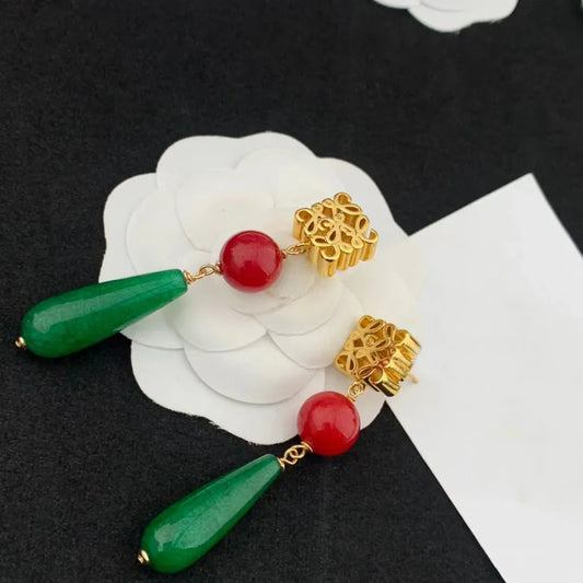 Gold filigree earrings with red round beads and long green teardrop drops