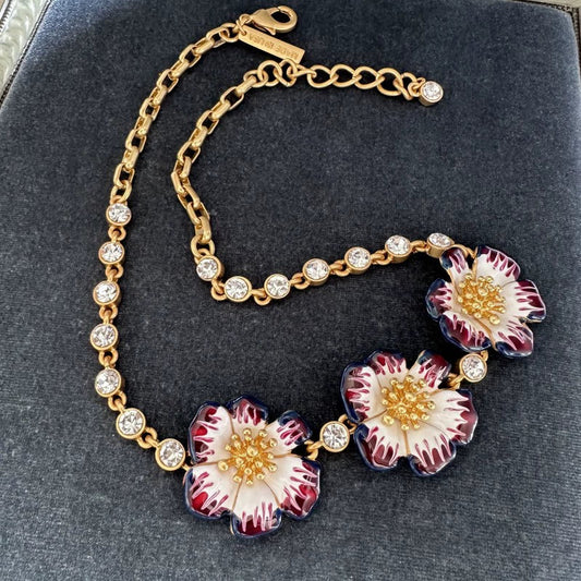 Gold enamel cherry blossom pendant necklace with red-and-white flower petals and crystals