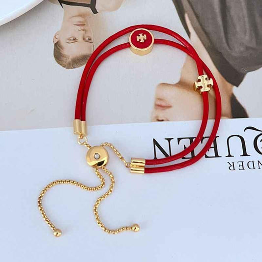 Red leather bracelet with gold round logo charm and chain extender, clasp detail