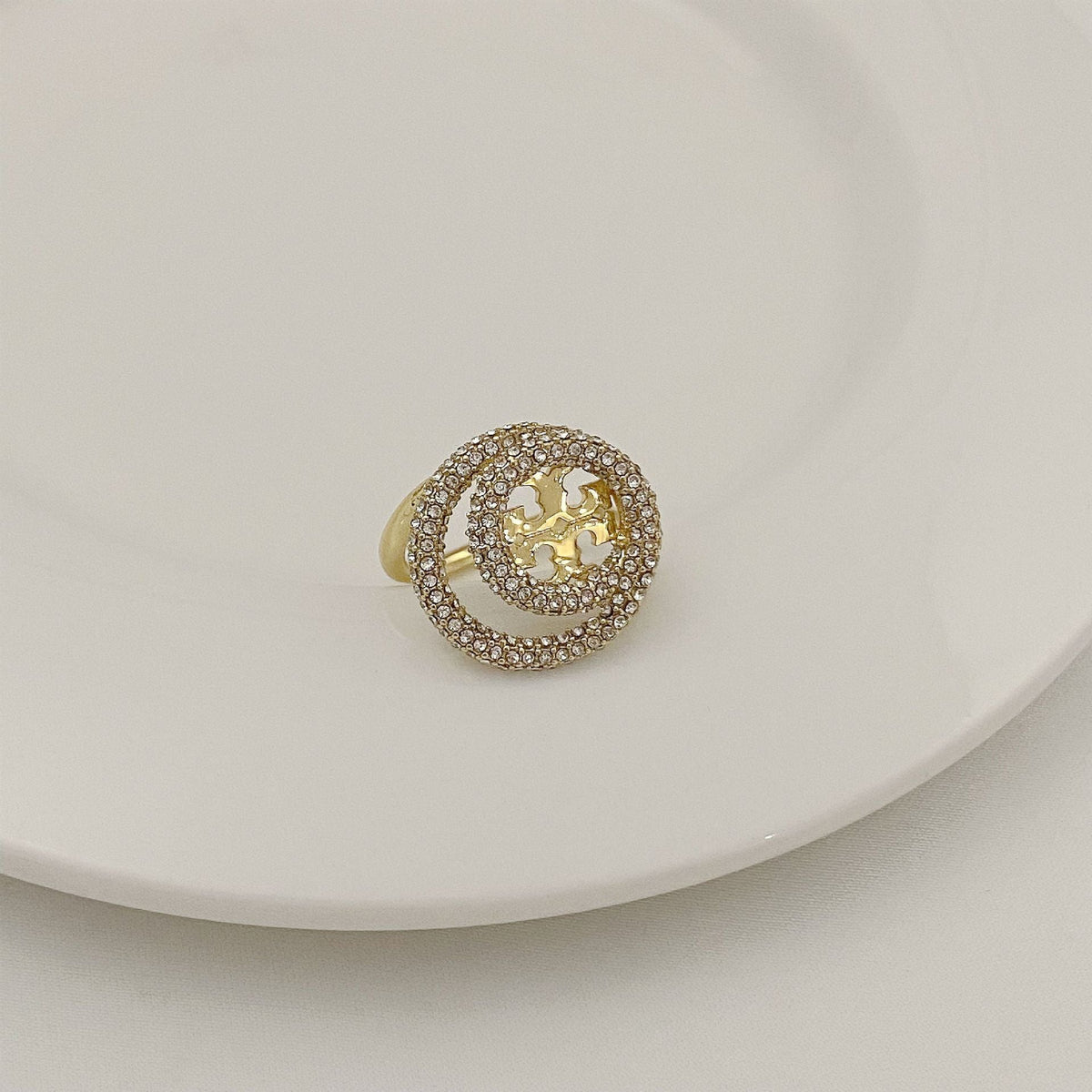 Gold-tone round ring with micro-paved outer band and gold filigree star centerpiece.