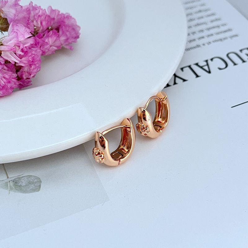 Rose gold-tone U-shaped metal hoop earrings, smooth finish, side view