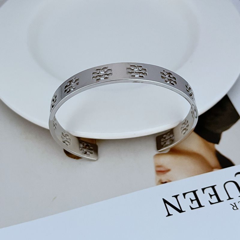 Silver-tone openwork logo open bangle cuff with repeating cutout pattern