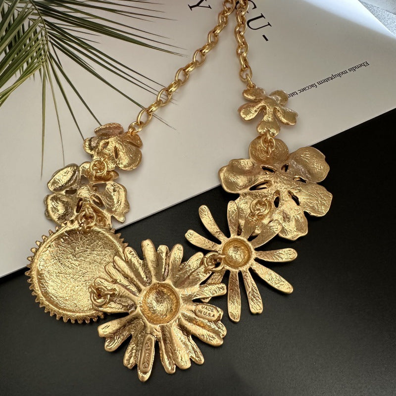 Gold-tone enamel daisy flower necklace with multiple floral charms and textured petal details