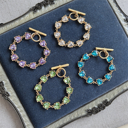 Gold-tone heart crystal bracelet with purple, blue, and green faceted stones