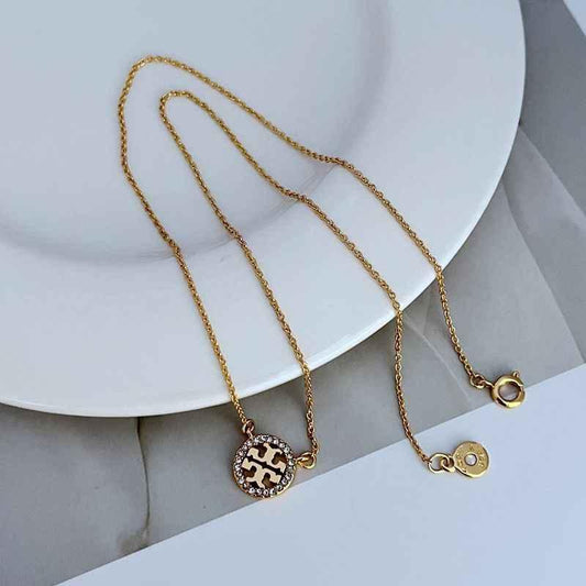 Gold-tone openwork pendant necklace with round diamond-studded charm disc and chain