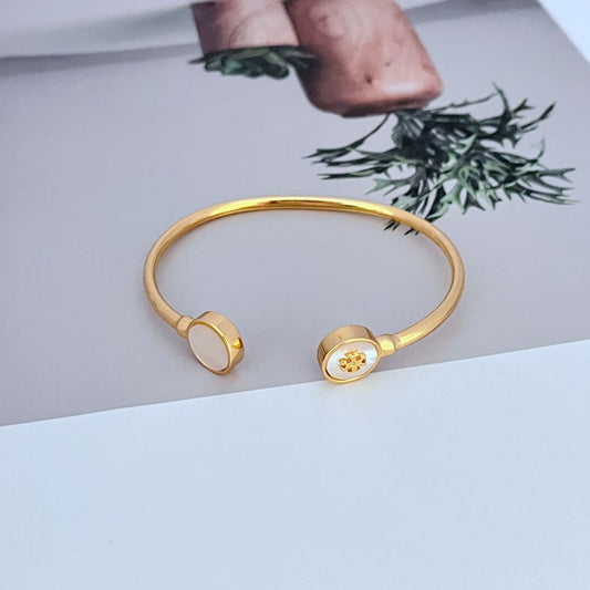 Round enamel shell open gold-tone metal bangle with white disc ends