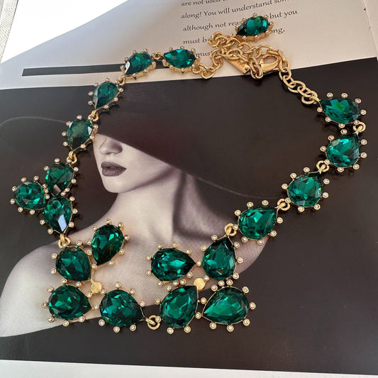 Gold-tone crystal necklace with teal/emerald oval stones and linked chain