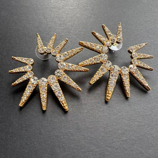 Gold-tone starburst stud earrings with faceted clear stones