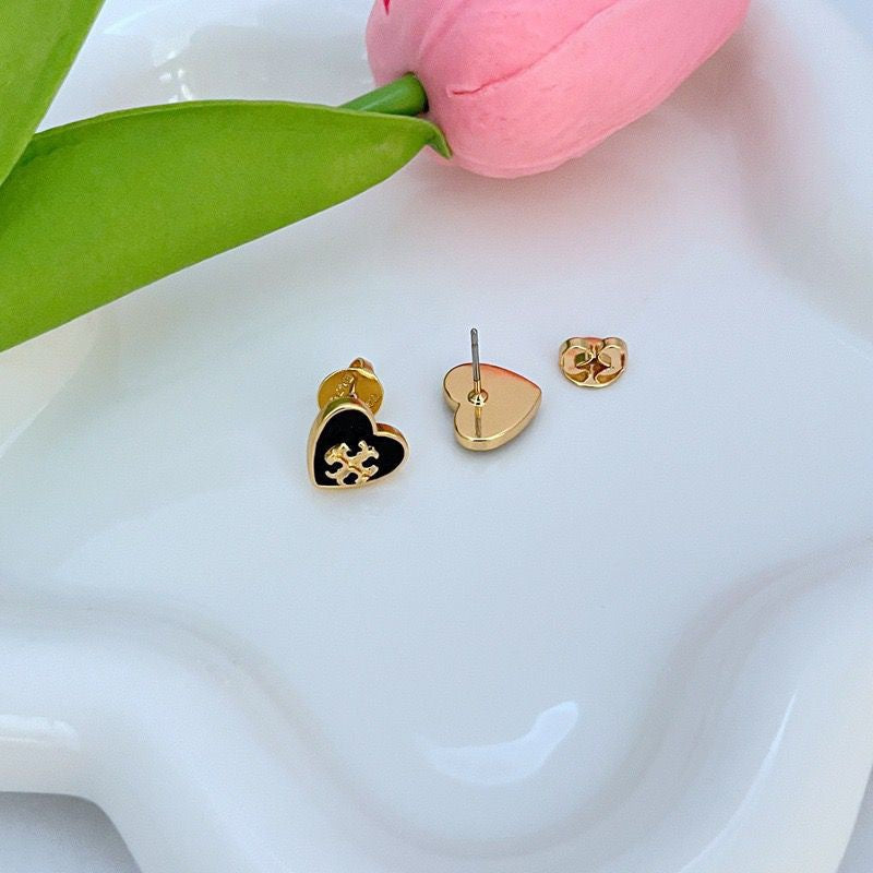 Heart stud earrings set with gold-tone posts; black and white enamel heart faces