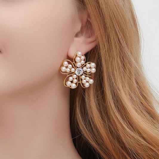 Floral stud earrings with white pearls and gold-tone openwork petals