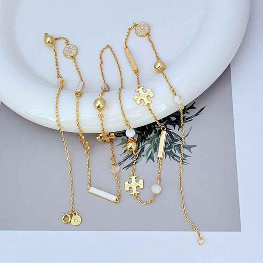 Tory Burch patchwork enamel sweater necklace with gold chains, heart charms, pearl accents