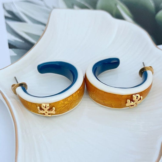 Pair of hoop earrings with gold-brown enamel outer, white trim, deep blue interior
