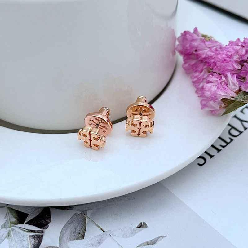 Rose gold-tone metal logo stud earrings, close-up pair with round backs