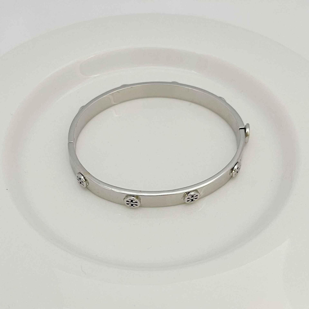 Silver open bangle bracelet with embossed logo accents