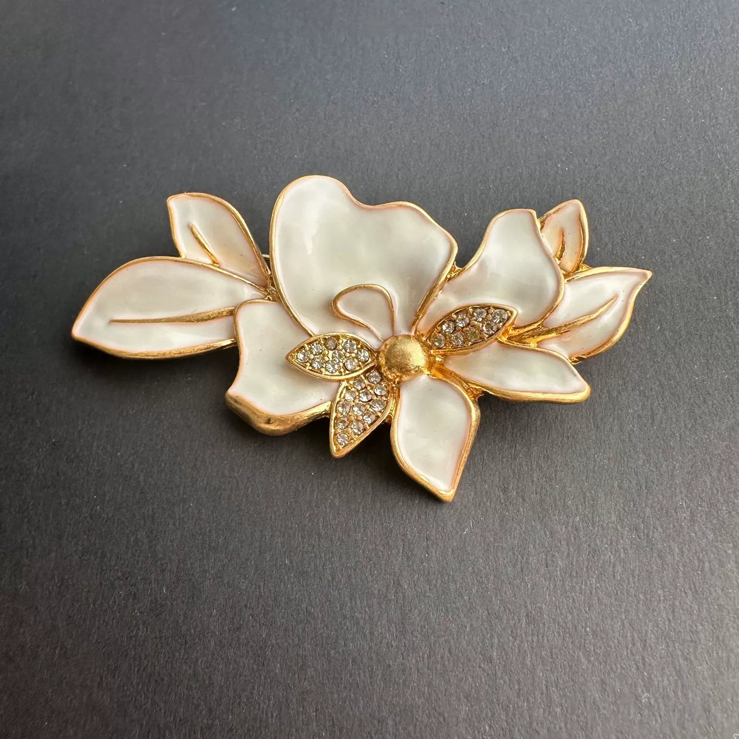 Enamel jasmine flower brooch with white enamel petals and gold rhinestone center