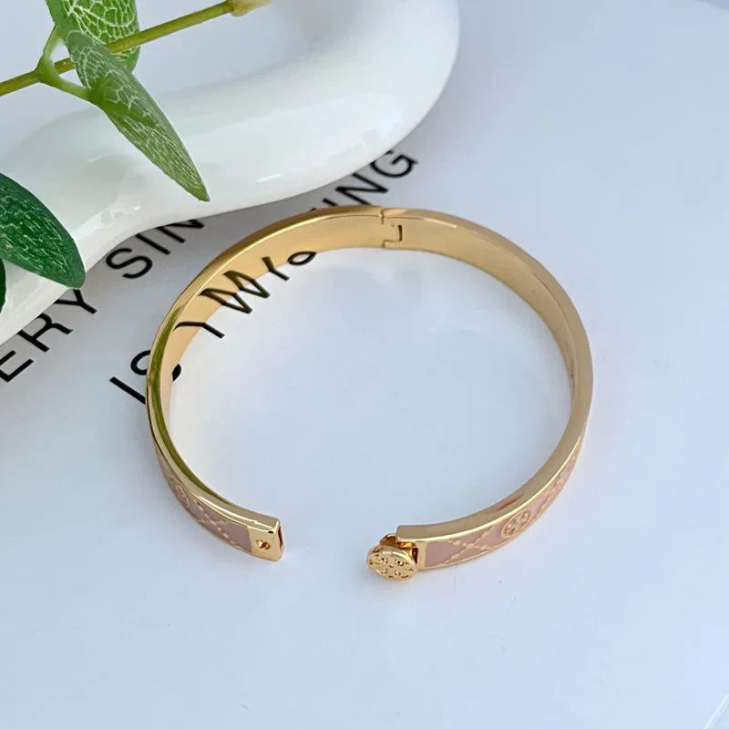Open enamel metal bracelet, gold-tone with pink enamel band and square logo accents