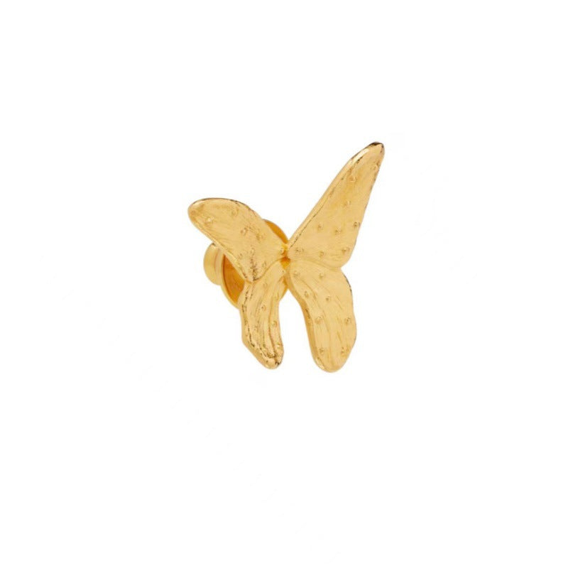 Gold butterfly stud earring with textured wings and visible post