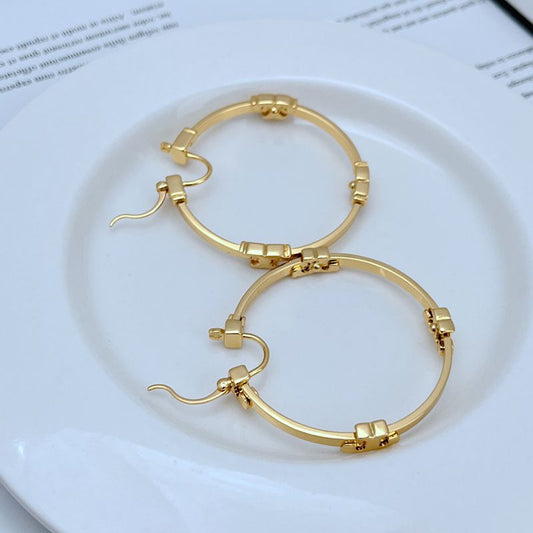 Gold-tone round hoop earrings with segmented high-shine metal and hook closures