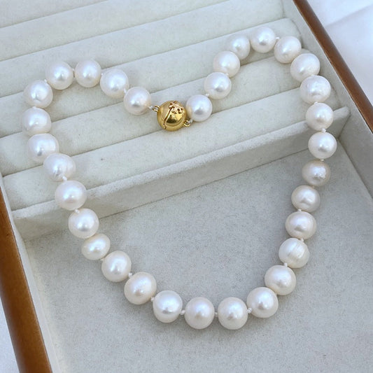 White pearl necklace with round pearls and gold magnetic clasp